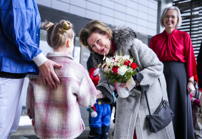 Ved ankomst overrakte fem år gamle Milla Skogli Holstad og barnesykepleier Linn Tandberg blomster til Dronningen. Foto: Beate Dahle Oma / NTB